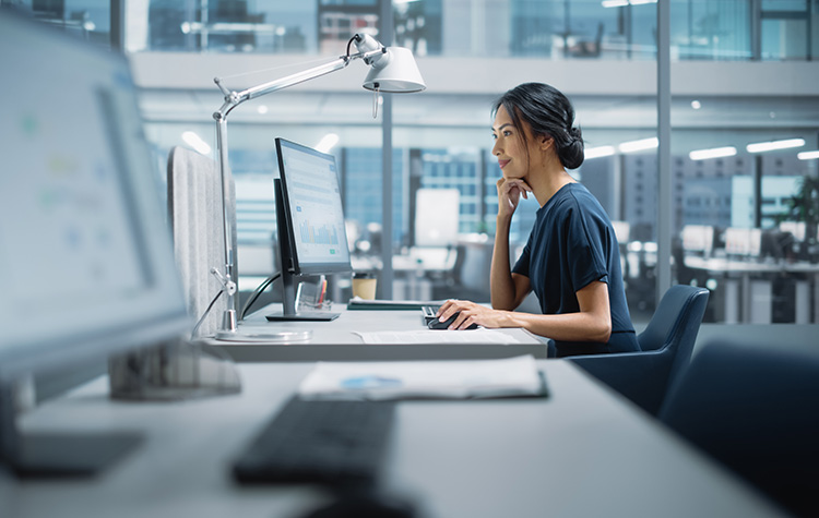 Business Frau sitzt im Büro vor ihrem Rechner